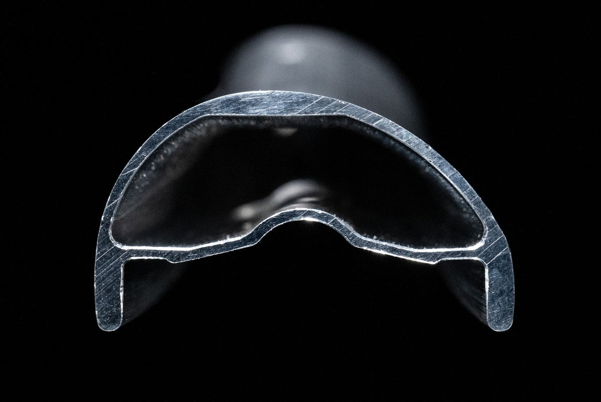Cross-section of the Coven AL rim extrusion on a black background.