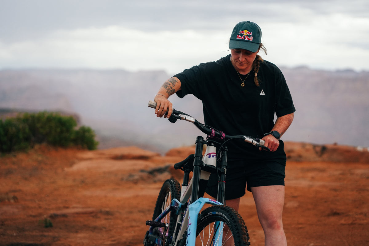 Hannah Bergemann with her bike on the red rock.
