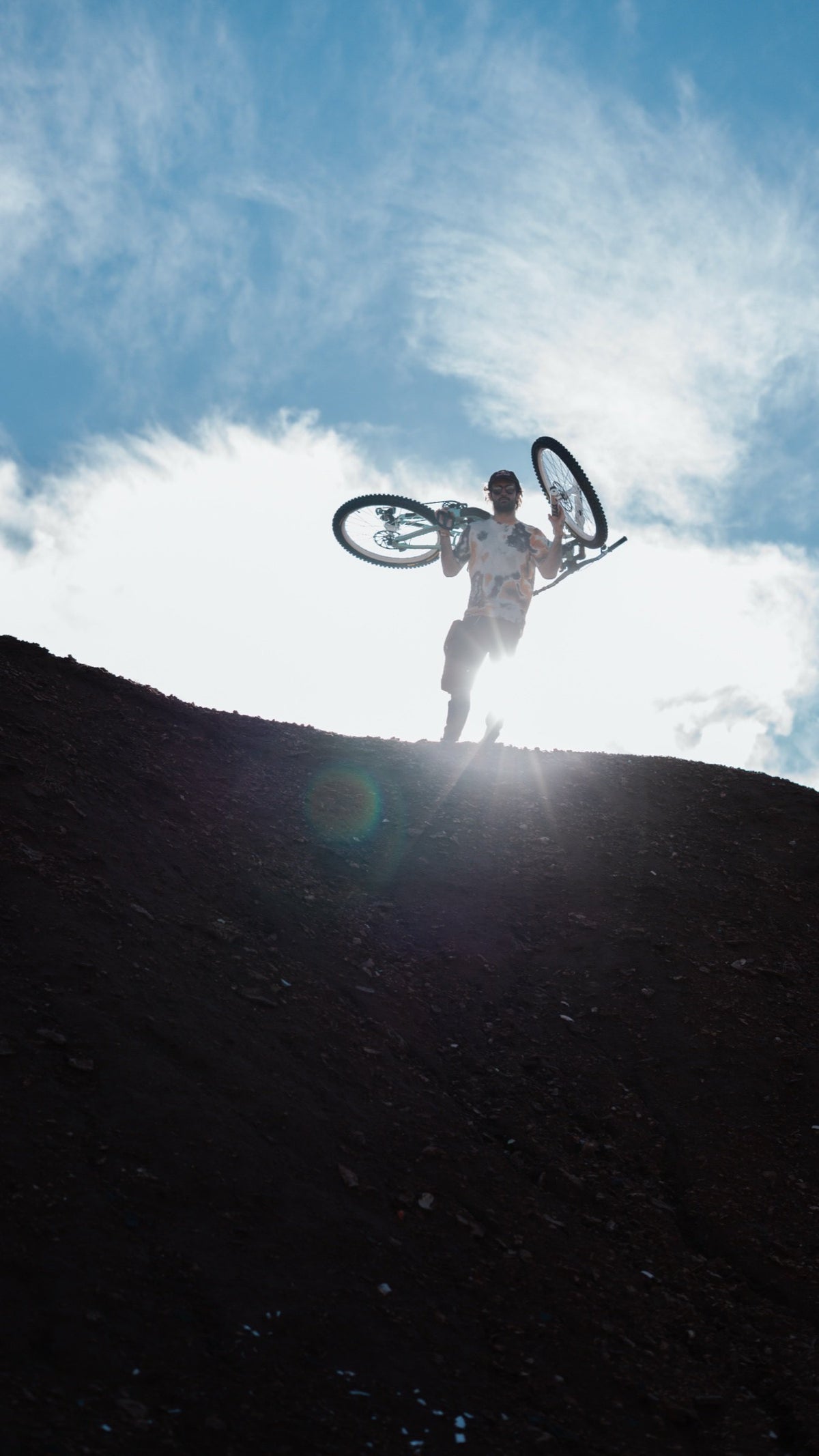 Johny Salido lifts his front wheel against a bright sky.