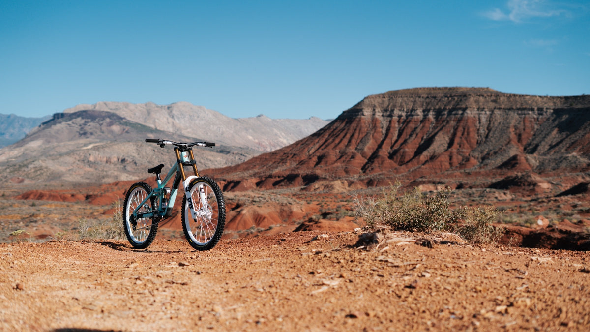 Johny's bike small against a wide desert landscape.