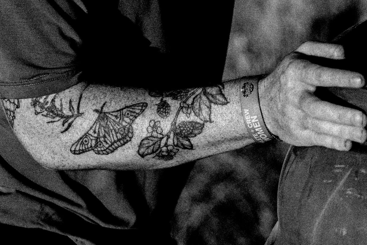 Tattooed forearm of a dig crew member in black and white. Photo: Robin O'Neill.