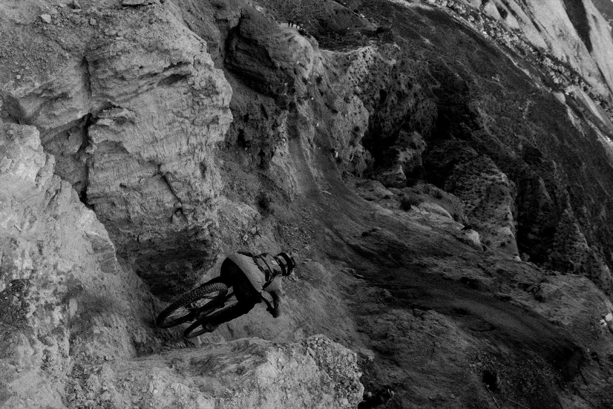A rider drops through a rocky chute in black and white. Photo: Robin O'Neill.