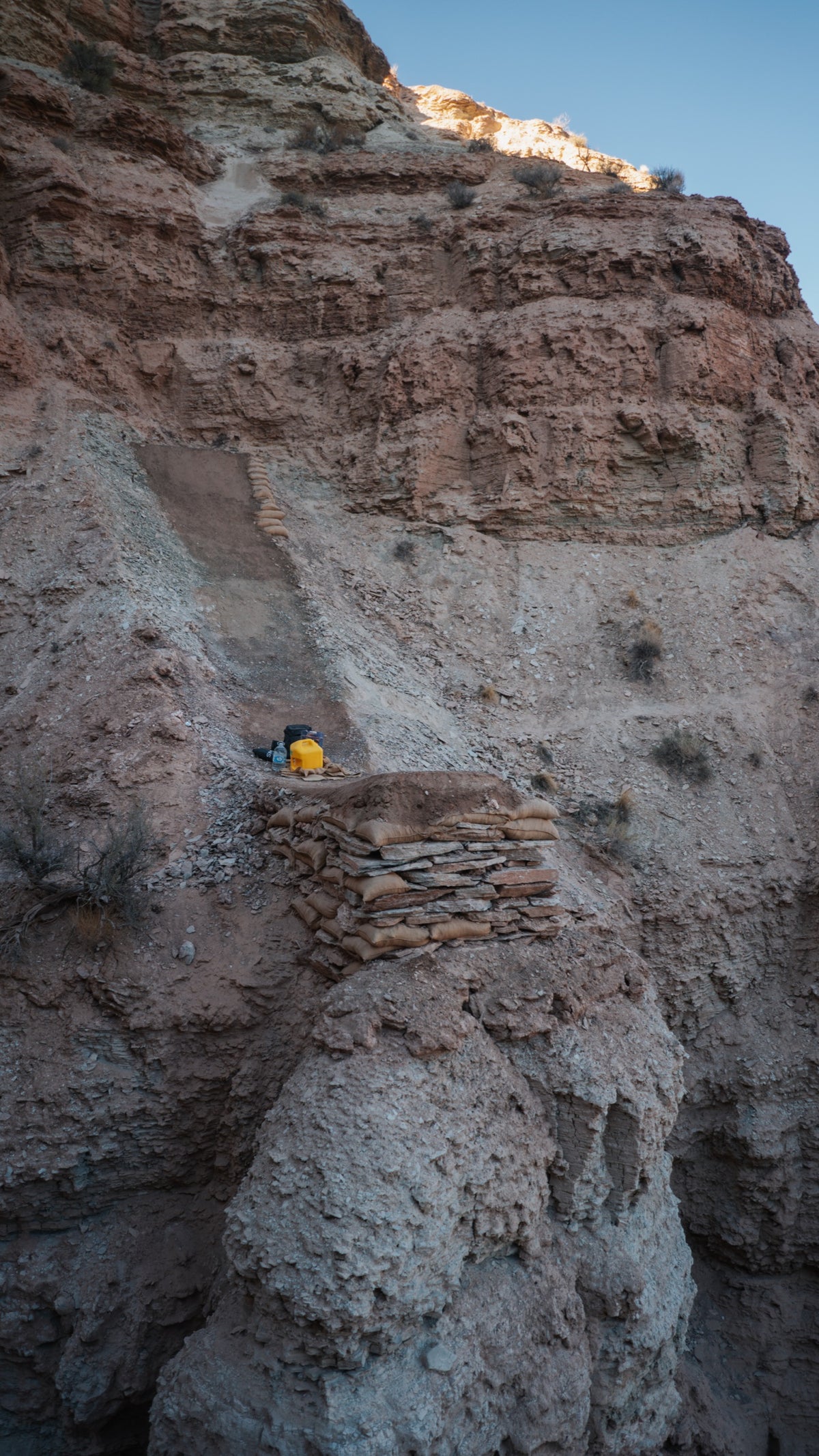 Stacked sandbag features on a cliff face.