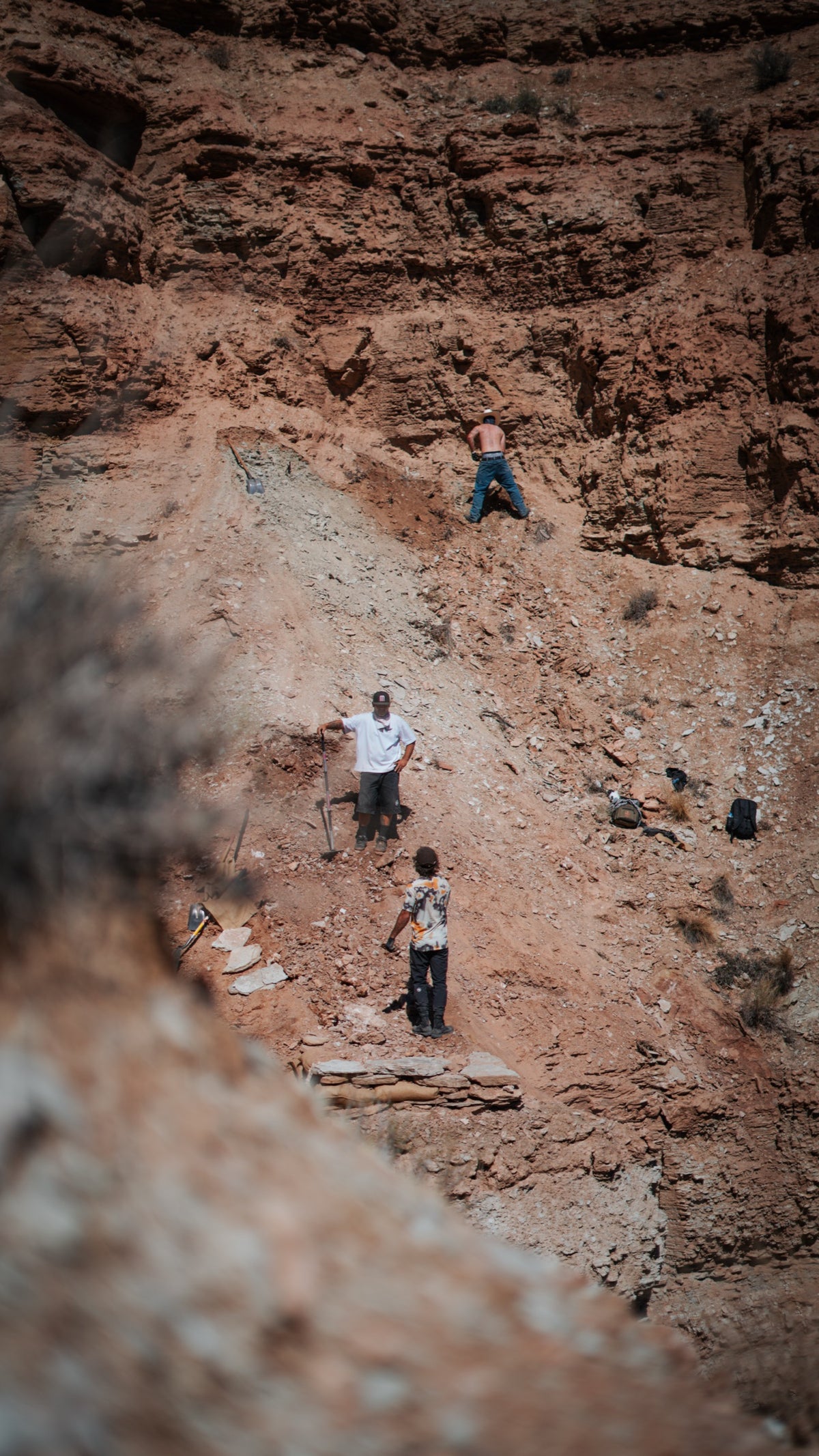 Diggers at work far down a steep face.
